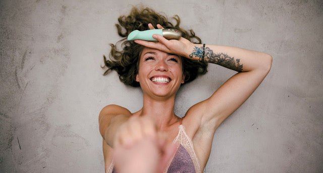 Woman laughing with Fun Factory's SUNDAZE pulse vibe in her hand
